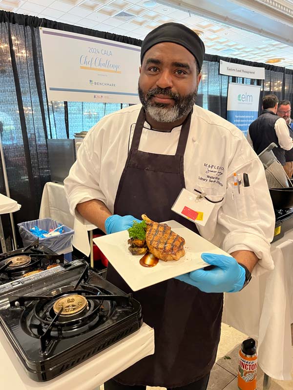 A chef competing in the CALA Chef Challenge presenting his dish.